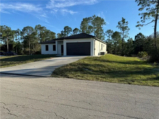 View of front facade featuring a garage and a front yard