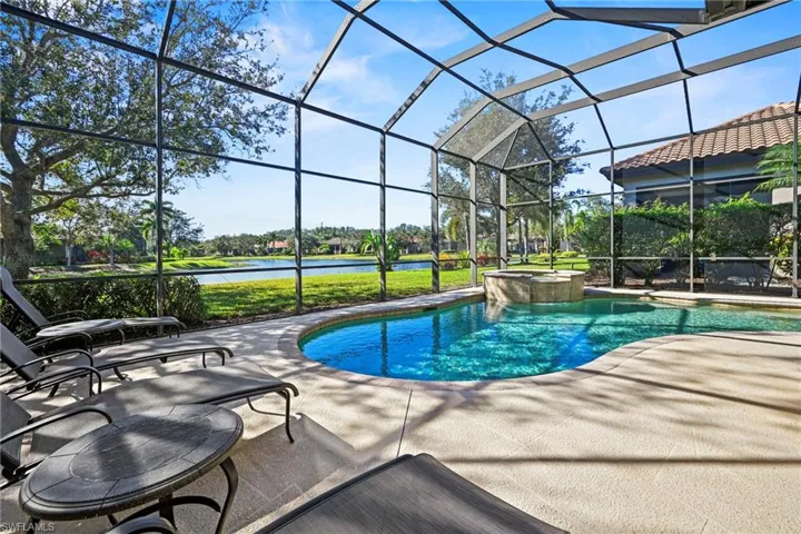 View of swimming pool with a water view, a pool with connected hot tub, a lanai, and a sunroom