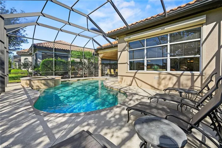 View of pool with a lanai, a patio, a sunroom, and a pool with connected hot tub
