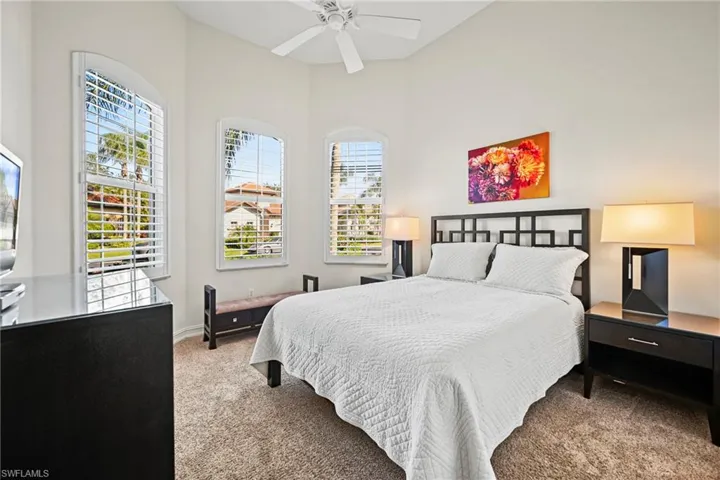 Carpeted bedroom with a ceiling fan