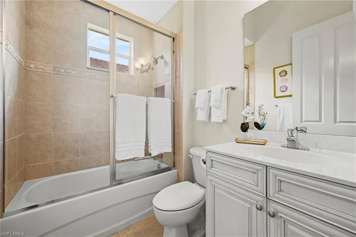 Full bath featuring vanity and bath / shower combo with glass door