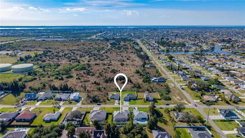 Birds eye view of property with a water view and a residential view