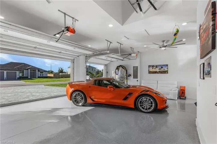 Garage with recessed lighting, electric panel, and a garage door opener