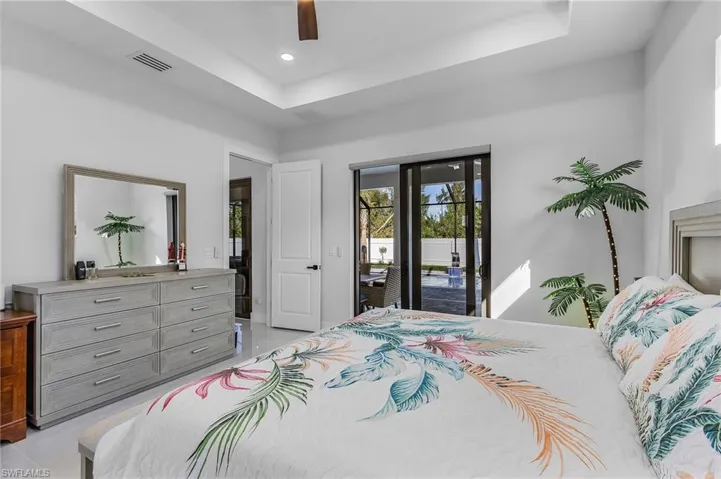 Bedroom featuring visible vents, a ceiling fan, access to outside, a tray ceiling, and recessed lighting