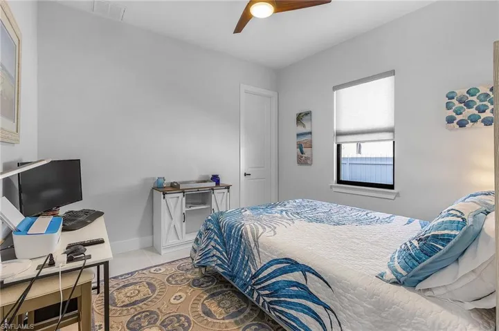 Bedroom with light tile patterned flooring, a ceiling fan, and baseboards