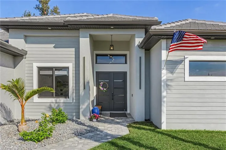 Entrance to property with a tile roof and stucco siding