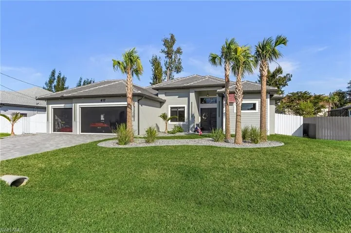 Prairie-style house featuring an attached garage, fence, decorative driveway, and a front yard