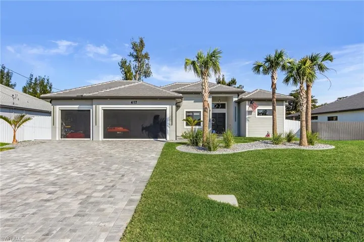 Prairie-style house with a garage, decorative driveway, a front yard, and fence