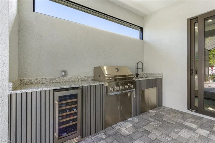 View of patio / terrace with beverage cooler, grilling area, a sink, and area for grilling