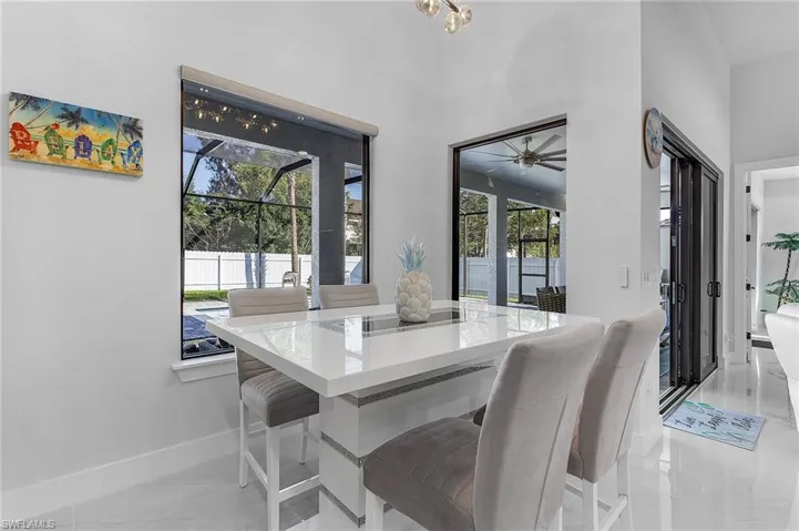 Dining area featuring a ceiling fan, a towering ceiling, and baseboards