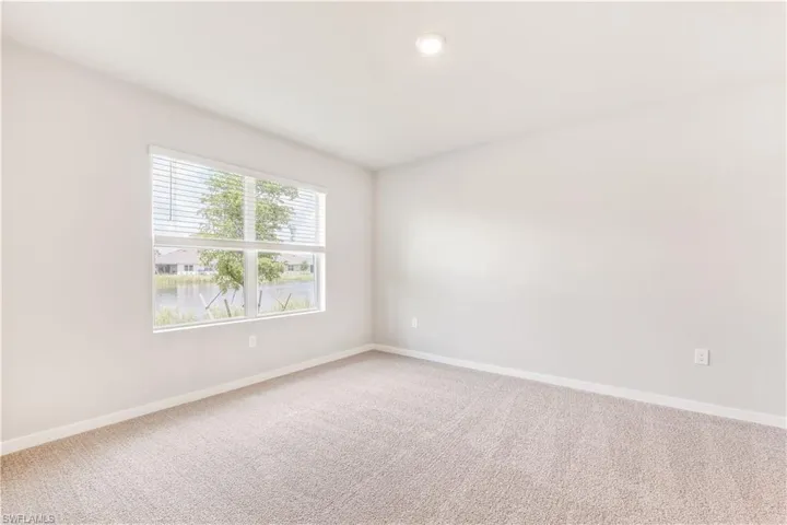 Carpeted empty room featuring baseboards and recessed lighting