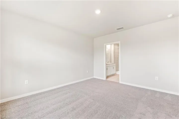 Empty room featuring light colored carpet and recessed lighting