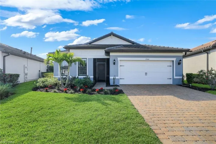 Ranch-style house with a garage, stucco siding, decorative driveway, screened entry way and a front yard