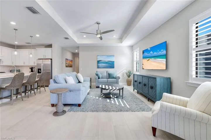 Living area with ceiling fan and tray ceiling