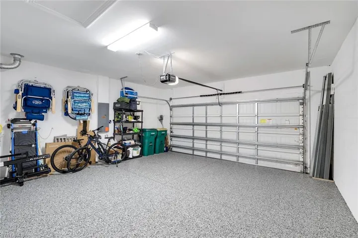 Garage with electric panel, a garage door opener and epoxy flooring