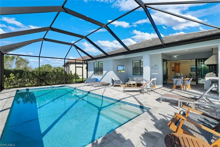 Swimming pool featuring a patio, lanai and outdoor kitchen