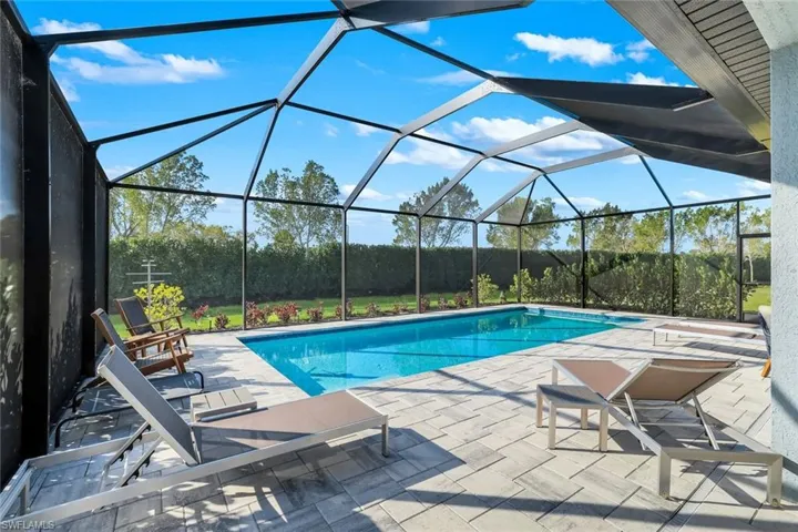 Outdoor pool with a patio, and screened enclosure