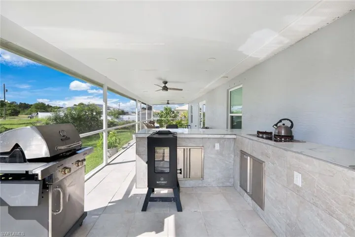 View of patio featuring ceiling fan and area for grilling