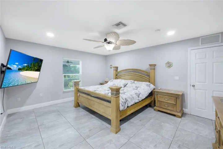 Bedroom featuring light tile patterned floors and ceiling fan