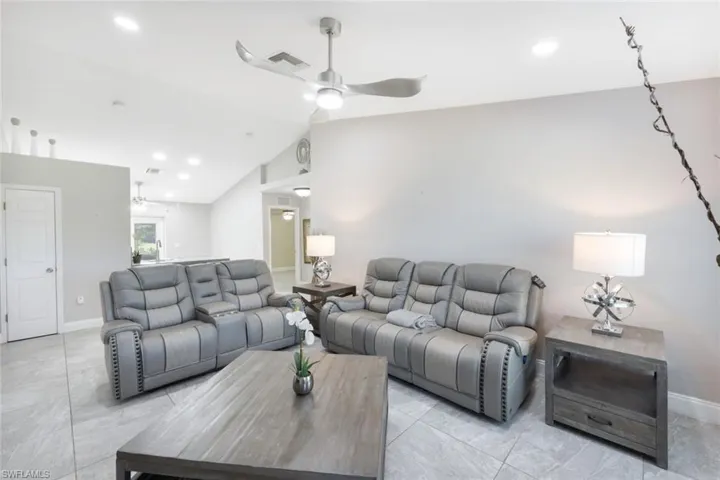 Living room with lofted ceiling and ceiling fan