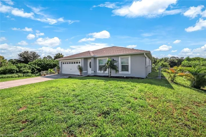 Ranch-style house with a garage and a front yard