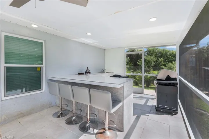 Sunroom with bar area and ceiling fan