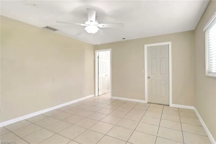 Spare room with a textured ceiling, ceiling fan, and light tile patterned floors