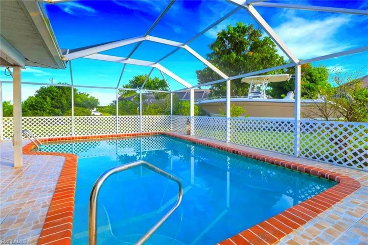 Swimming pool with glass enclosure, a sunroom, and a patio area