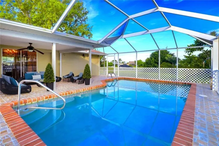 Outdoor pool featuring a lanai, an outdoor living space, a patio, and a sunroom