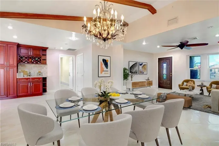 Dining room with recessed lighting, bar, a ceiling fan, and a chandelier