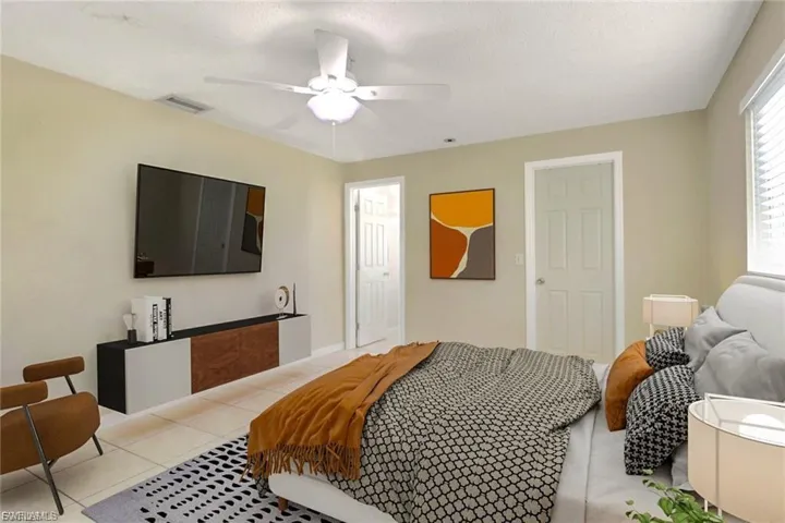 Bedroom with a ceiling fan, tile patterned flooring, and a textured ceiling