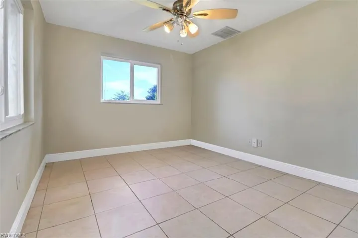 Unfurnished room featuring light tile patterned floors and a ceiling fan