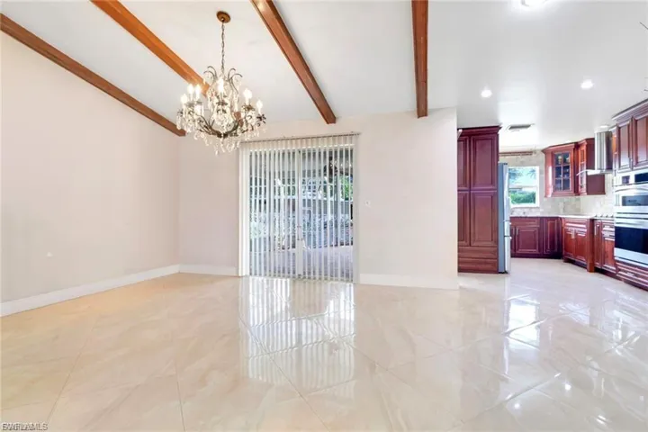 Unfurnished dining area with a chandelier and baseboards