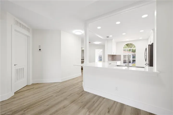 Kitchen featuring visible vents, white cabinets, light countertops, and freestanding refrigerator