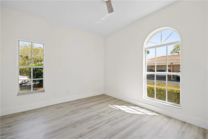 Spare room with ceiling fan, wood finished floors, and baseboards
