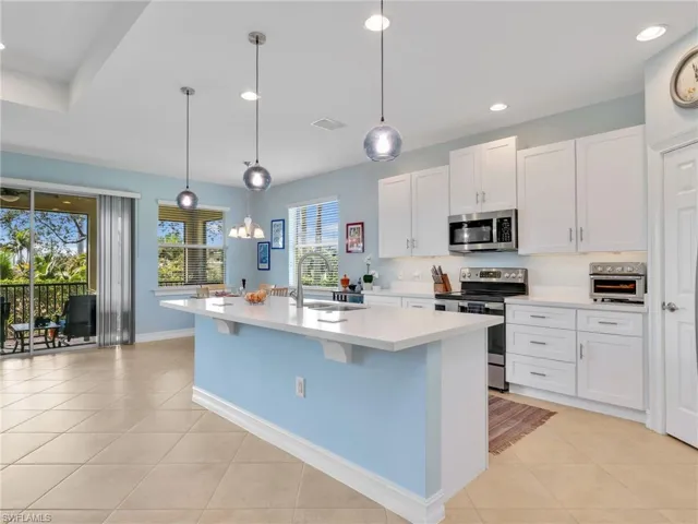 Kitchen with Island, Quartz Counters, Stainless Steel Appliances, and Stainless Steel Sink, Pantry, and Pendant Lighting