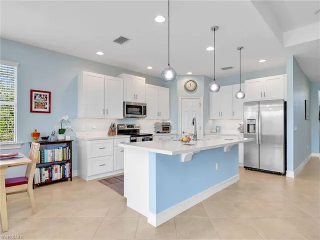 Kitchen with Island, Quartz Counters, Stainless Steel Appliances, and Stainless Steel Sink, Pantry, and Pendant Lighting