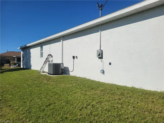 Back of house with a lawn