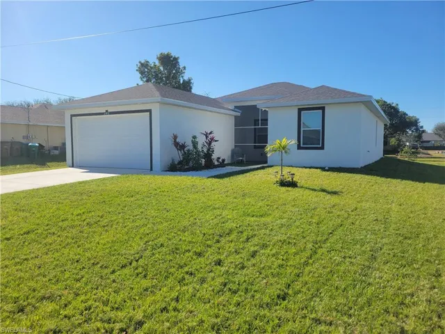 Single story home featuring an outbuilding and a front lawn