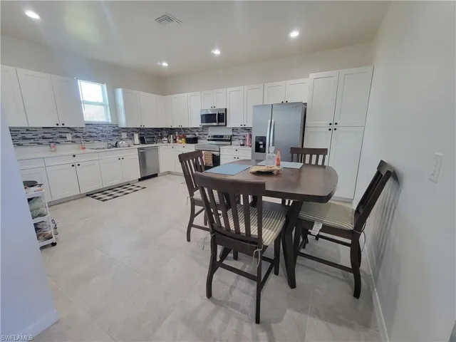 Kitchen with white cabinets, sink, and stainless steel appliances