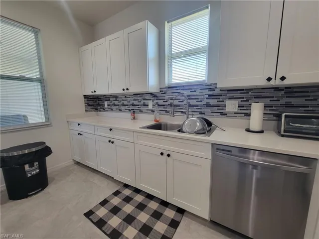 Kitchen with decorative backsplash and white cabinets
