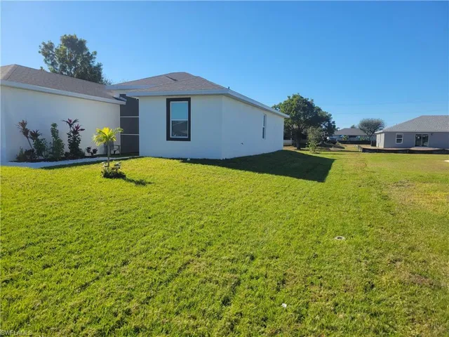 Single story home featuring a garage and a front lawn