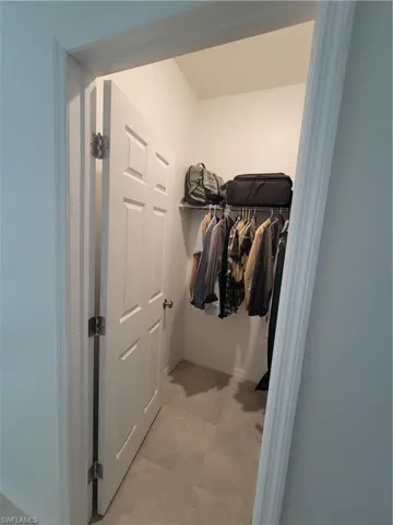 Spacious closet with light tile patterned floors