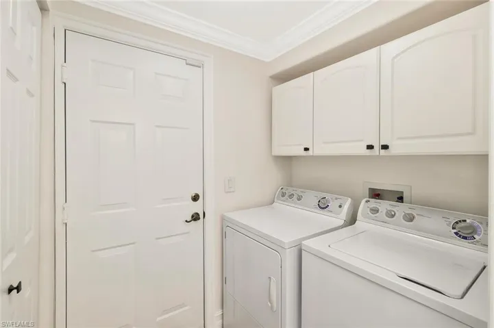Laundry room featuring crown molding, cabinet space, and independent washer and dryer