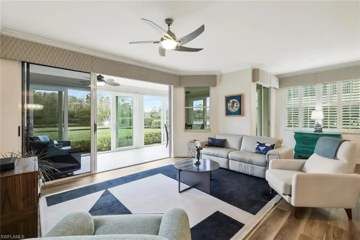 Living room with ornamental molding, wood finished floors, and ceiling fan
