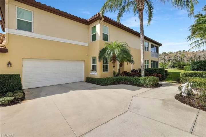 View of front facade with concrete driveway, a garage, stucco siding, and a tile roof