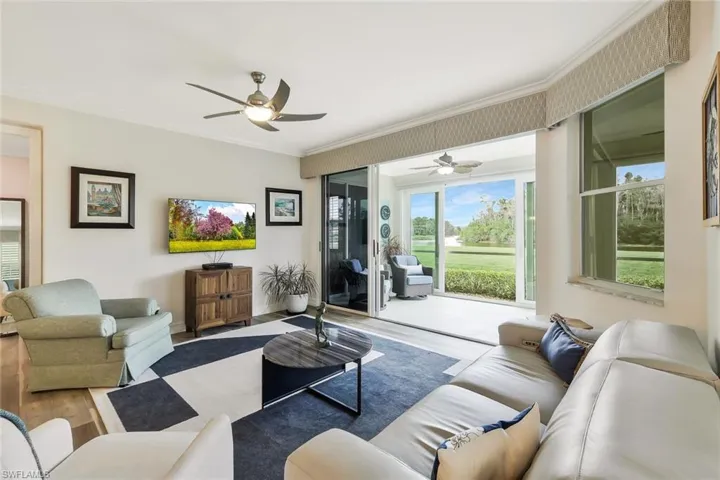 Living area featuring ceiling fan, wood finished floors, and crown molding