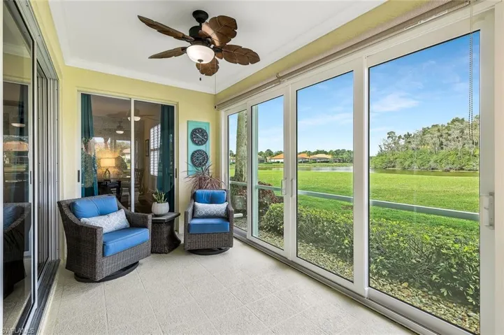 Sunroom featuring ceiling fan and a water view