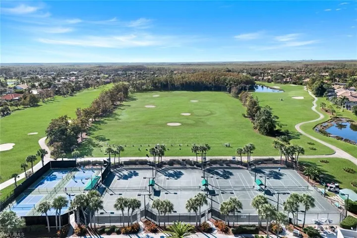 Drone / aerial view of a nearby body of water and a golf club