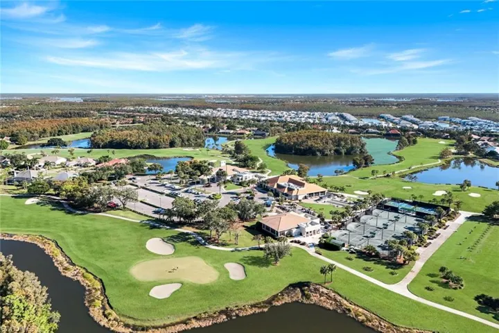 Aerial view of property's location with a golf course and nearby suburban area